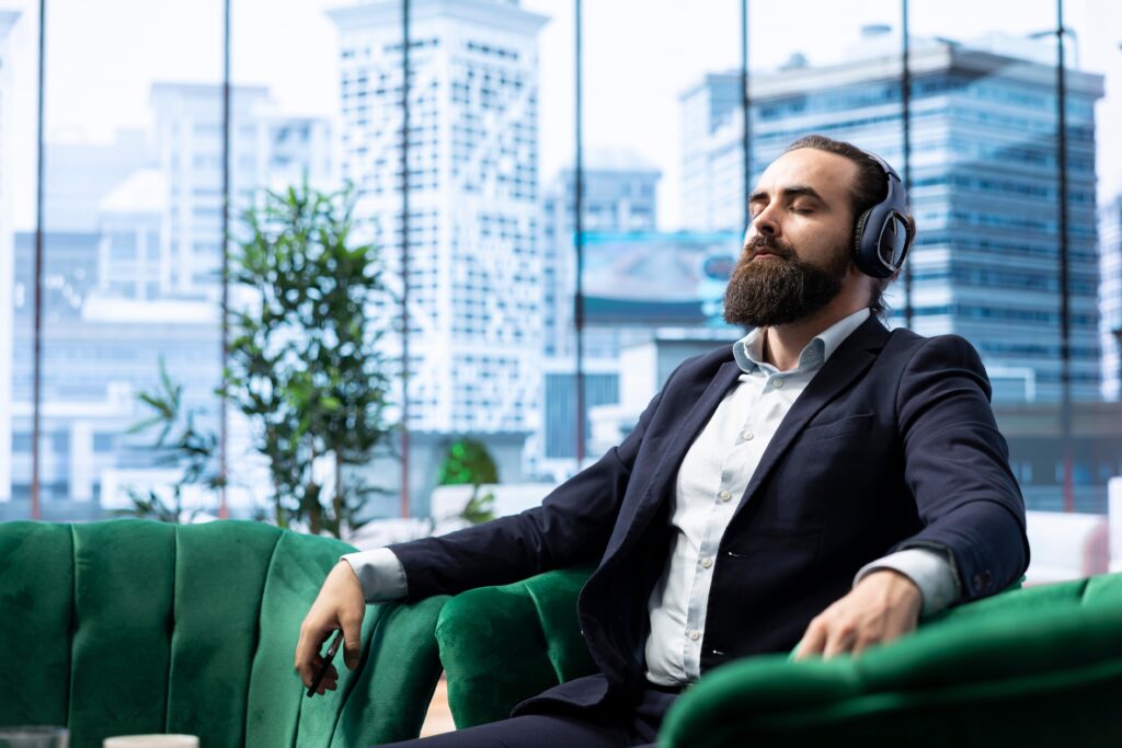 Man relaxing with headphones in office.