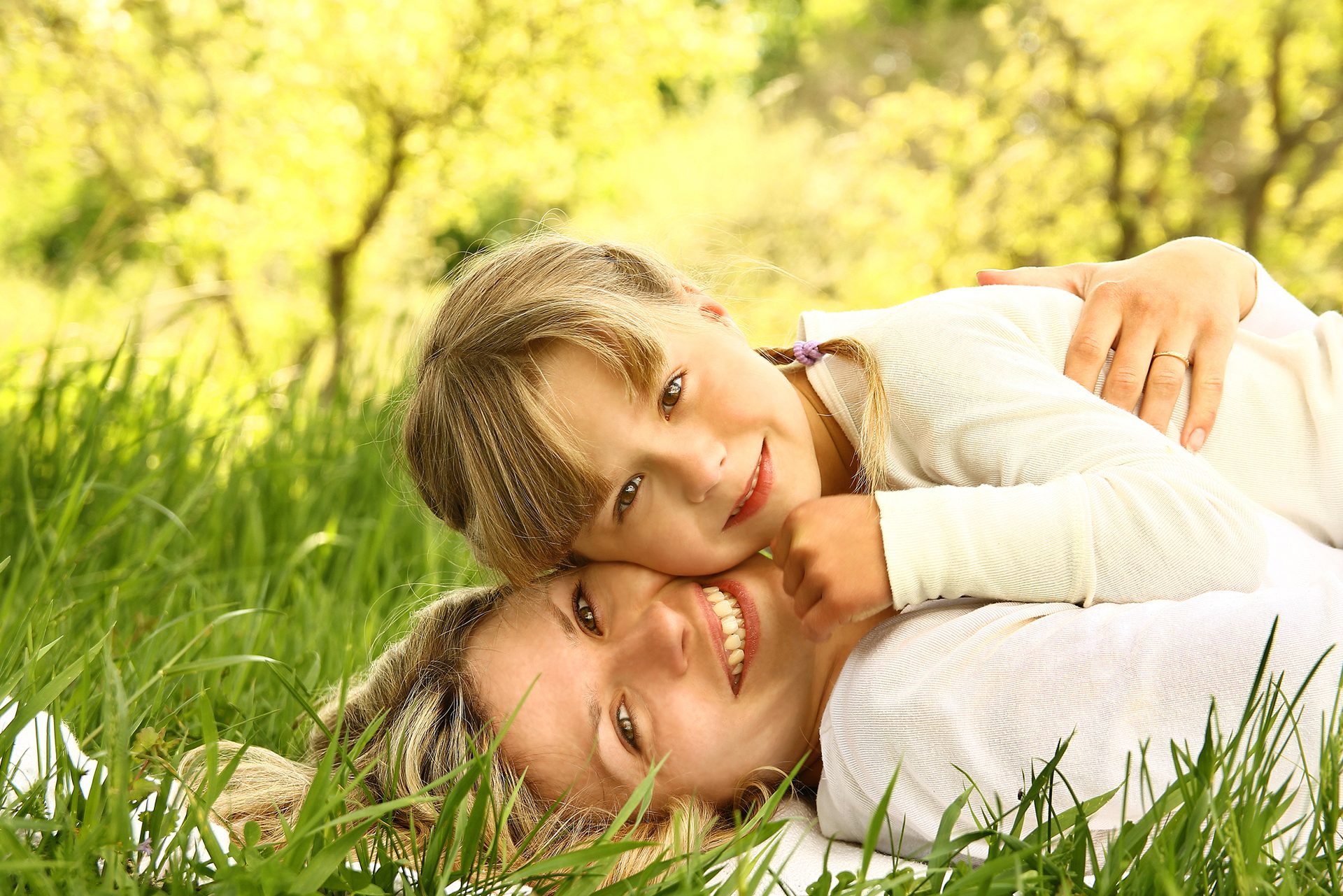 6 A woman and child laying in the grass.