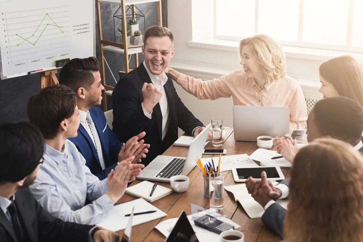 Team celebrating success in a meeting room.