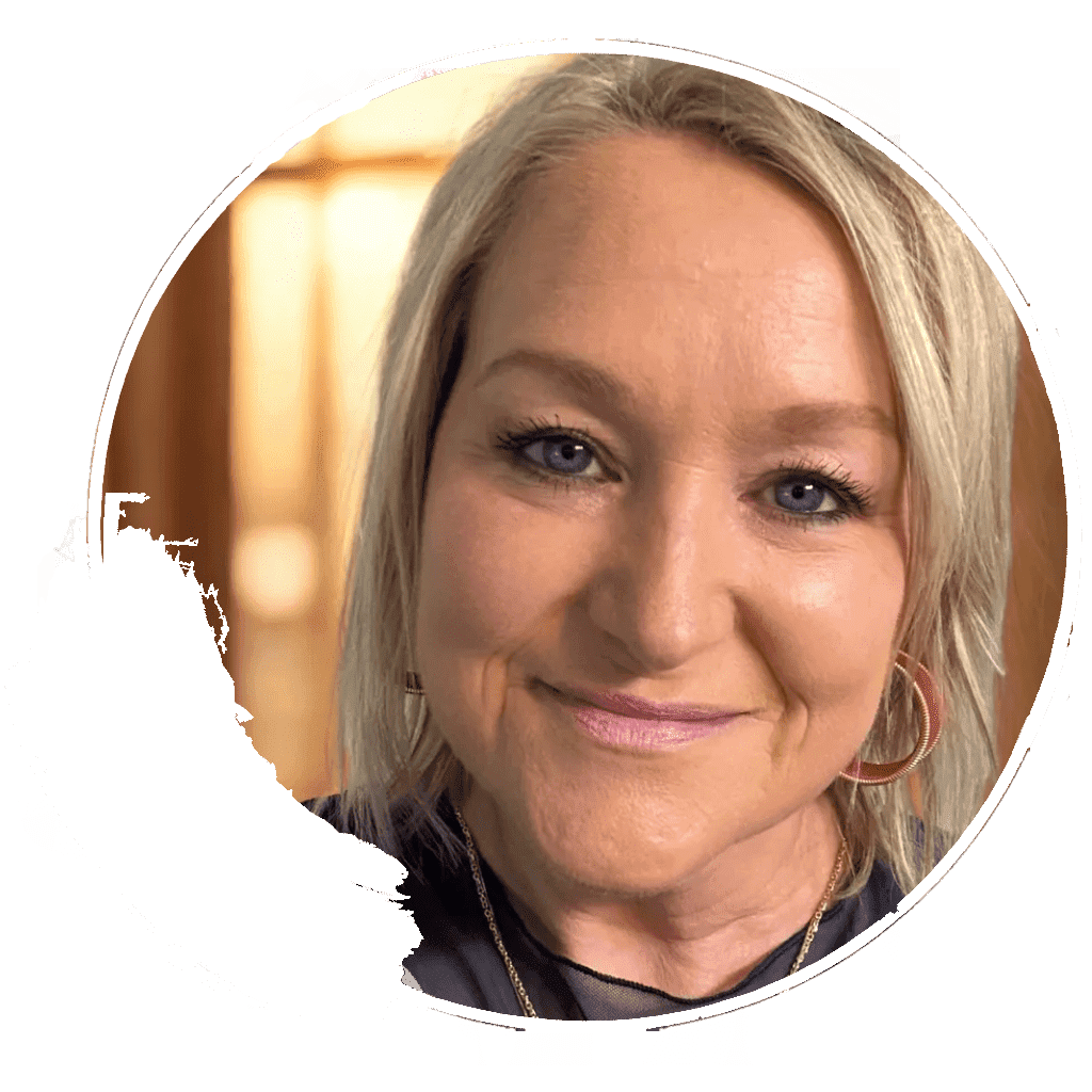 Smiling person with blonde hair and earrings.